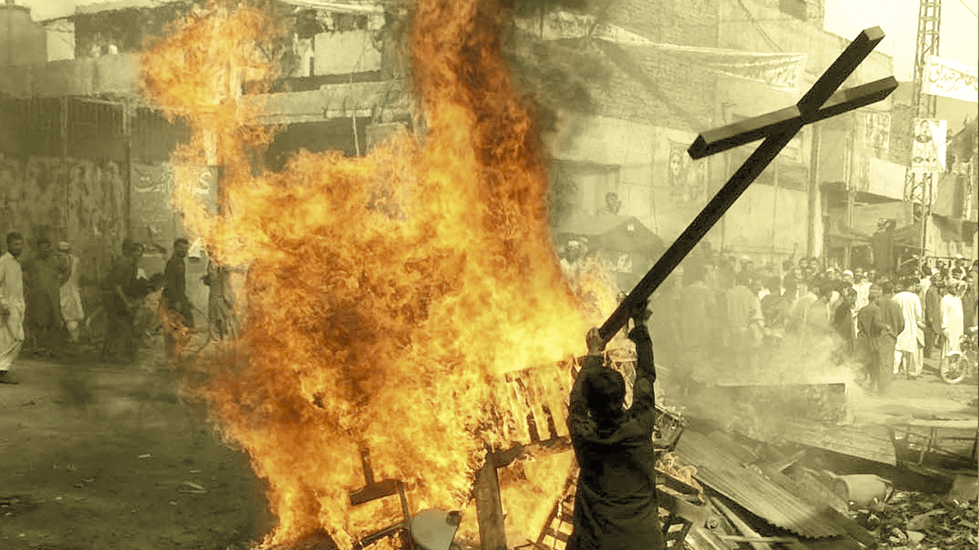Man holding a cross to throw into a fire - Persecution of Christians