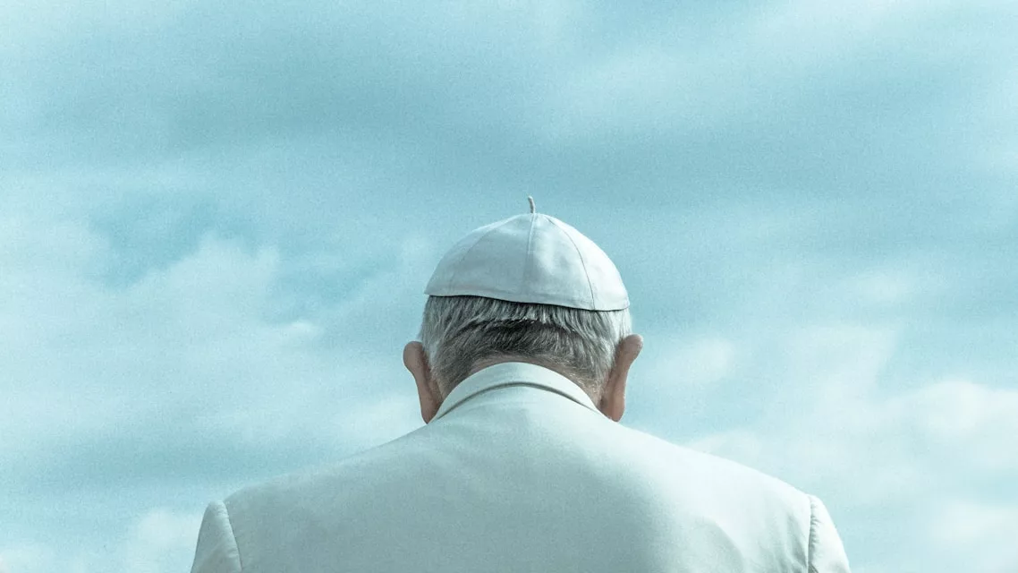 Pope Francis wearing white cap looking down under cloudy sky during daytime