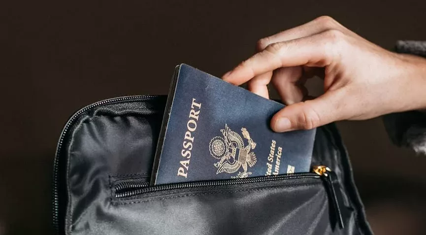 person putting a passport on bag
